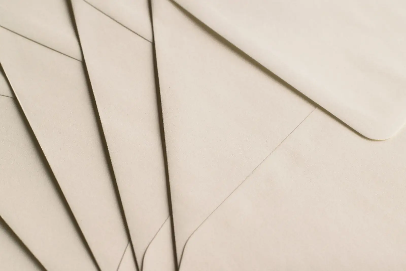Fanned stack of cream paper envelopes